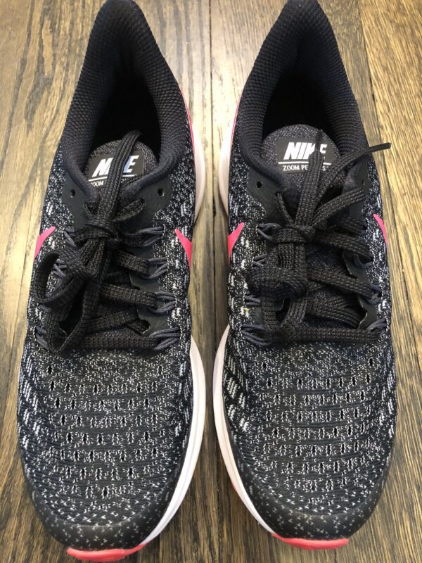 A pair of black and grey shoes on top of a wooden floor.