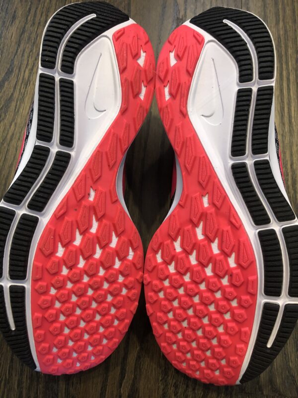 A pair of red and black shoes on the ground.