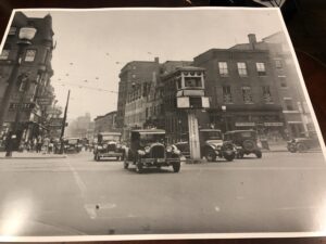A black and white photo of an old time street scene.