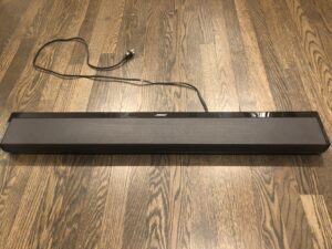 A long black bar sitting on top of a hard wood floor.