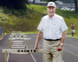 A man standing in front of a hurdle.