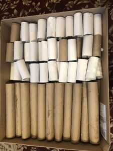 A box of toilet paper rolls sitting on top of the floor.