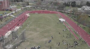 A group of people standing on top of a field.