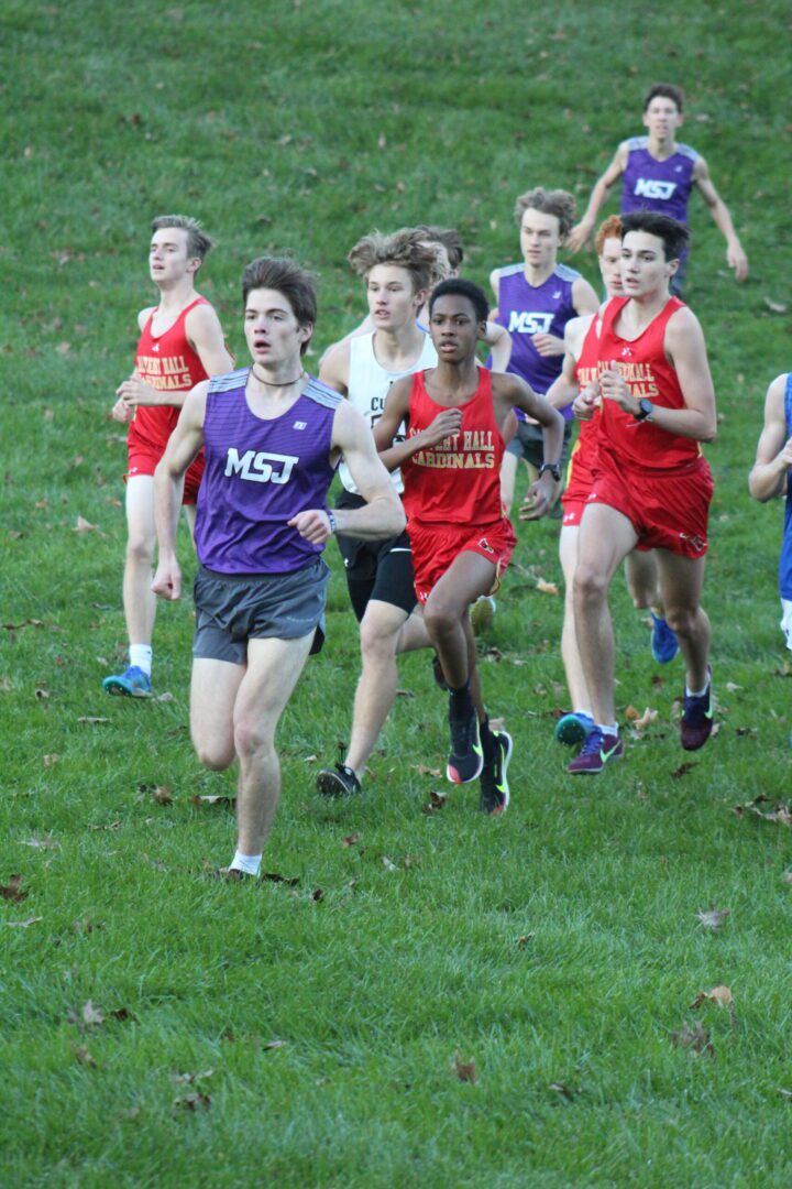 A group of young men running on the grass.