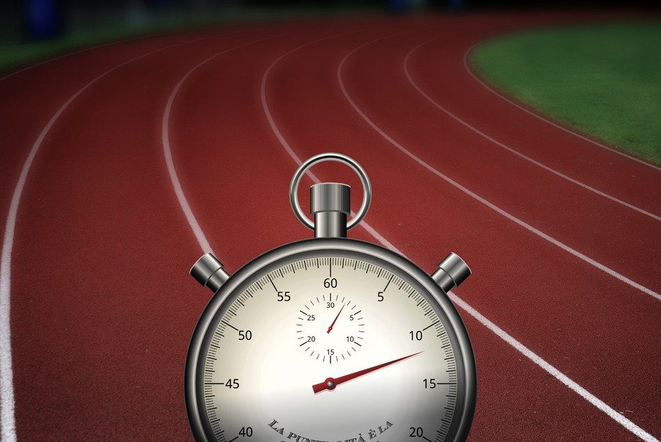 A stopwatch on the track of an outdoor stadium.