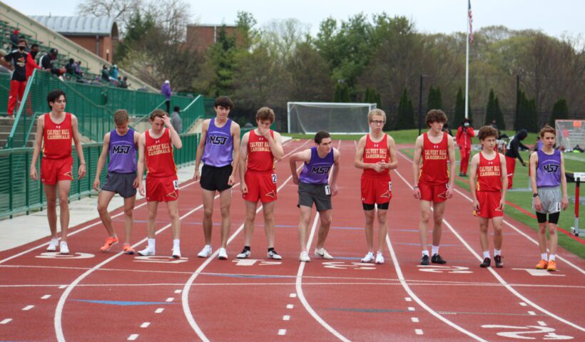 A group of young men standing on top of a track.