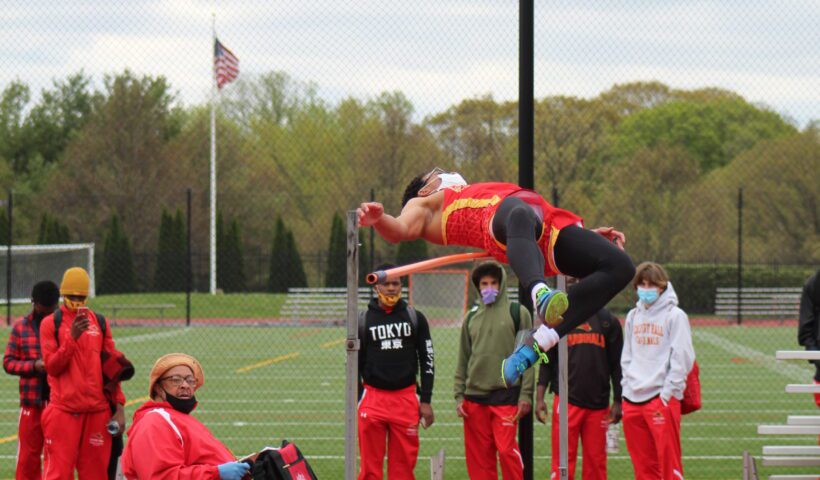A man jumping in the air over an obstacle.