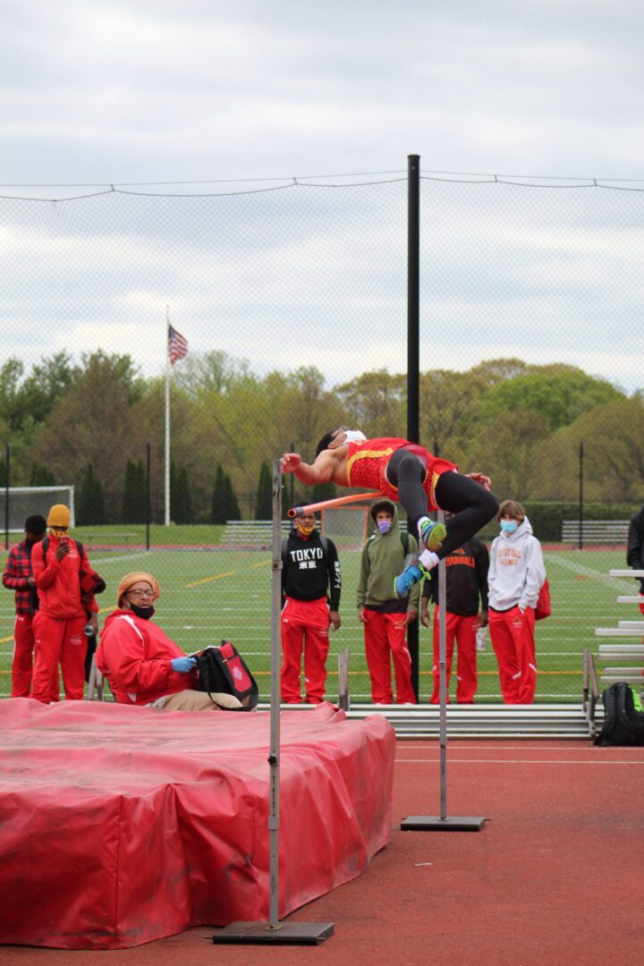 A man jumping in the air over an obstacle.