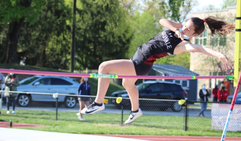 A person jumping over the bar in a track and field event.