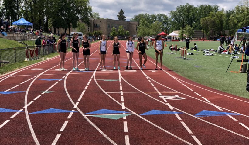 A group of people standing on top of a track.
