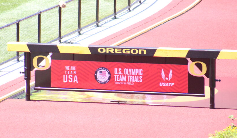 A sign on the side of a track for an olympic team.