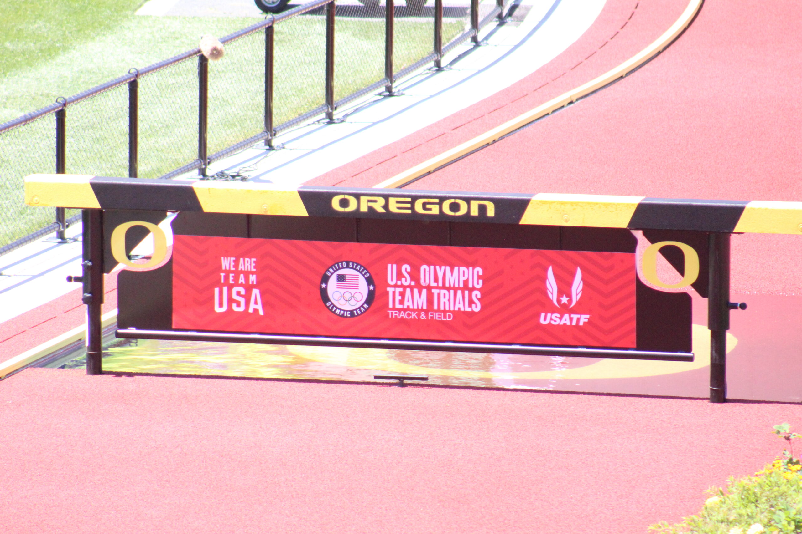 A sign on the side of a track for an olympic team.