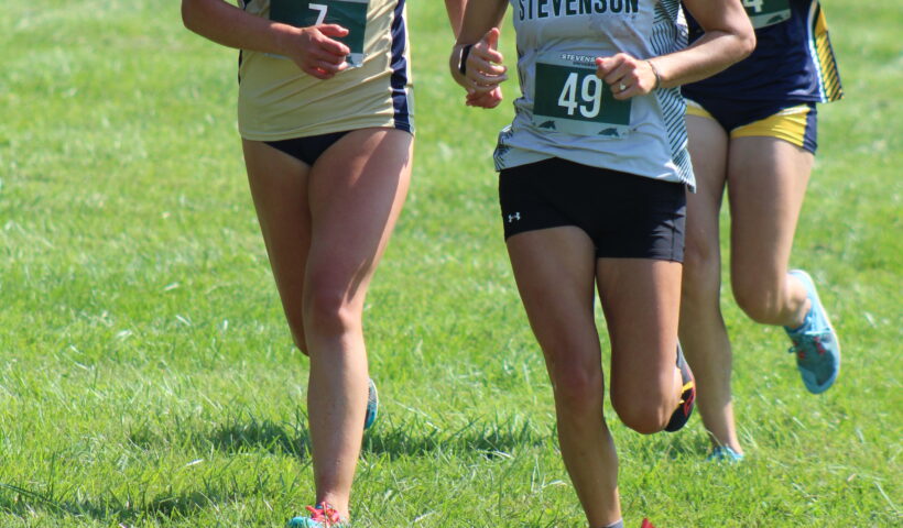 A group of girls running on the grass.