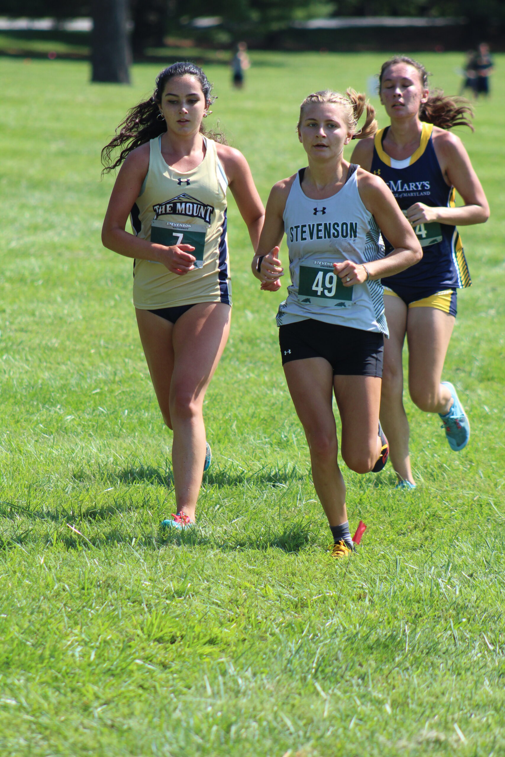A group of girls running on the grass.