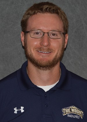 A man with glasses and beard wearing a blue shirt.