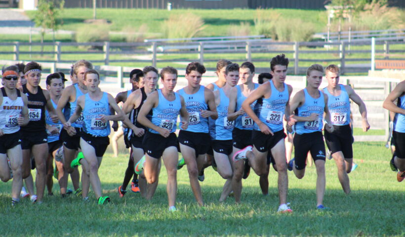 A group of young men running on the grass.