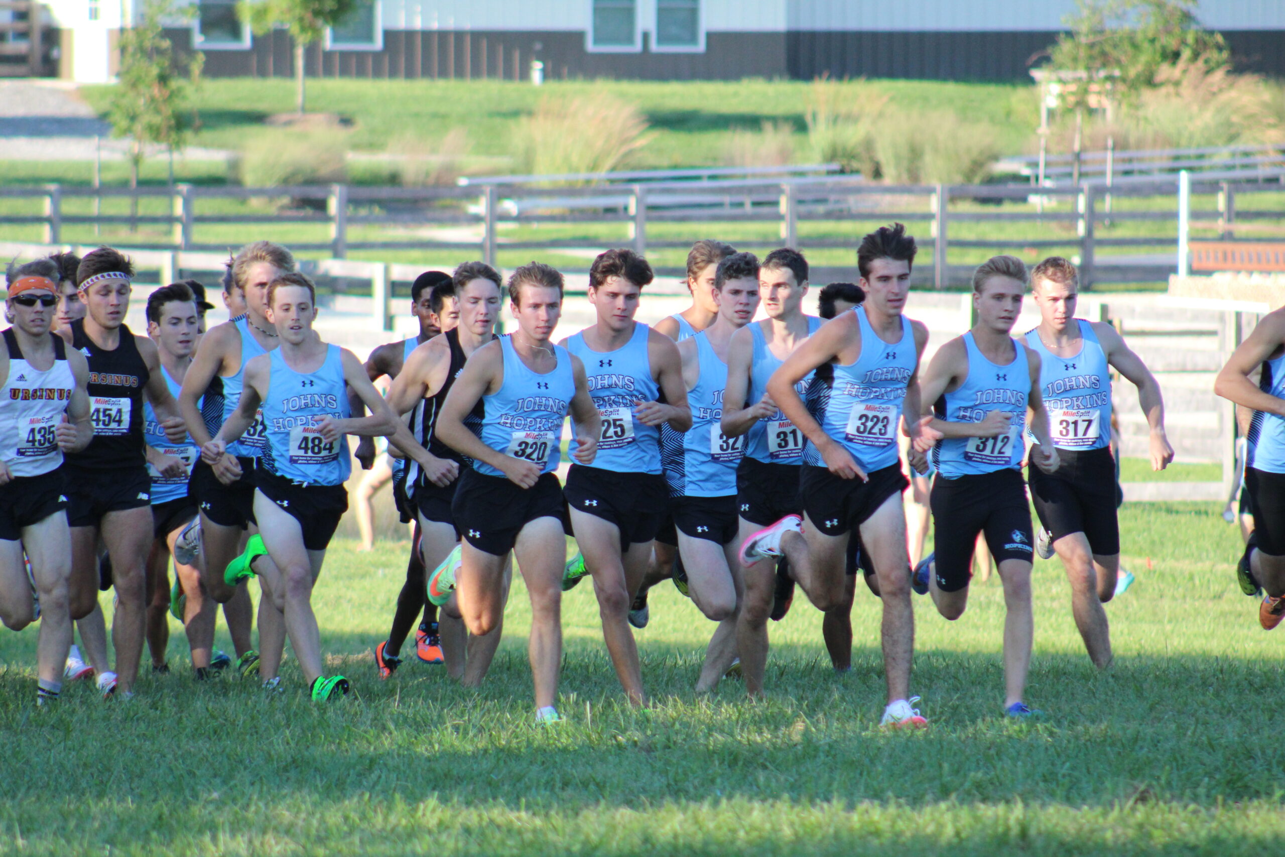 A group of young men running on the grass.