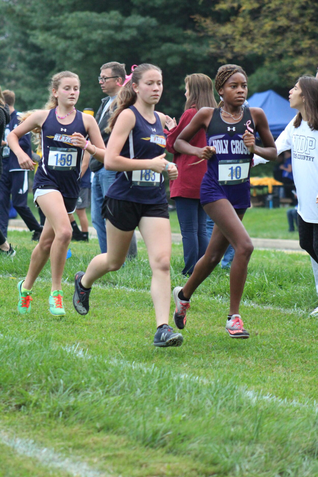 A group of young people running on the grass.