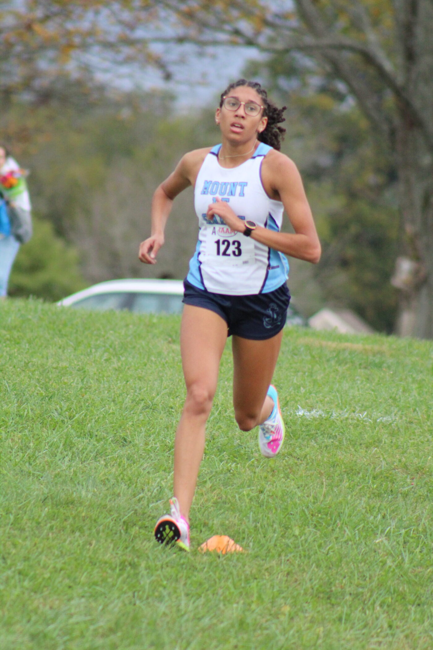 A woman running on the grass in a race.