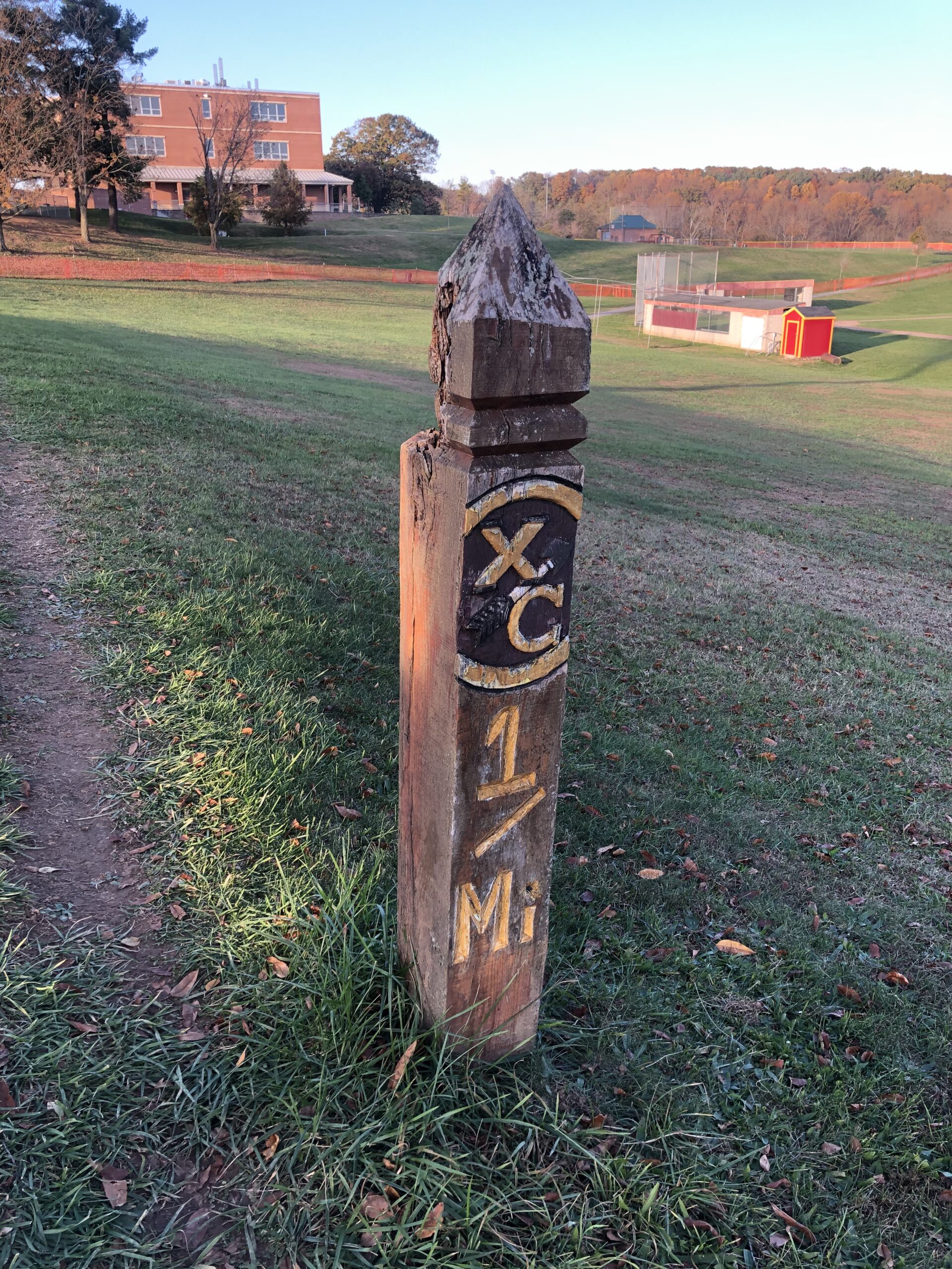 A wooden post with the initials xc and 1 m on it.