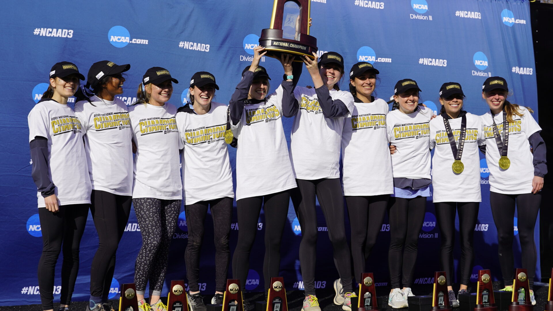 A group of women holding up trophies and posing for the camera.