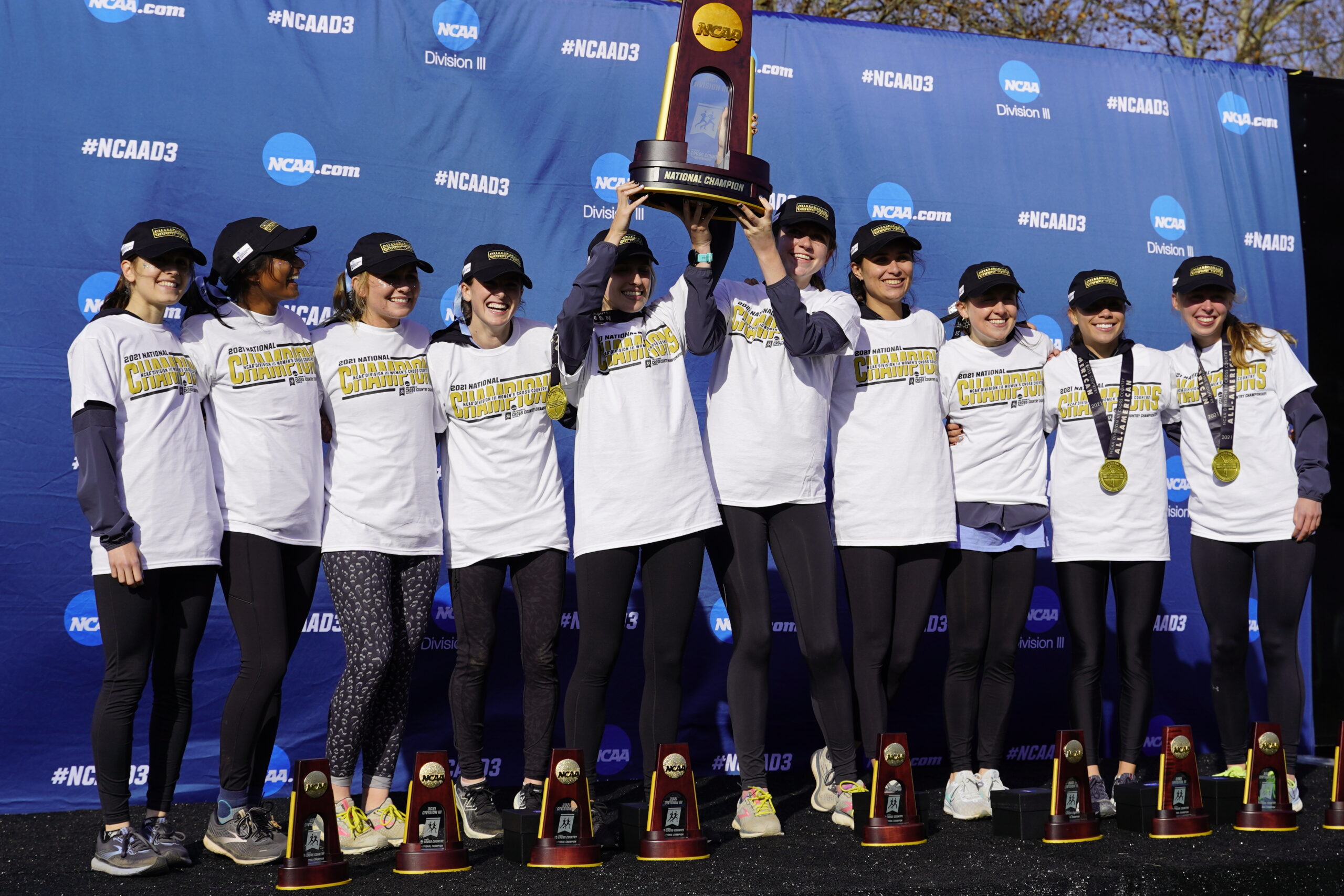 A group of women holding up trophies and posing for the camera.