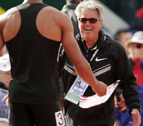 A man in black shirt shaking hands with another person.