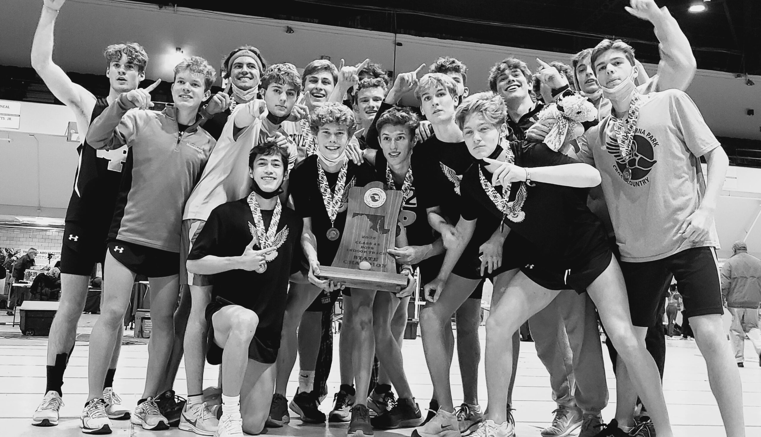 A group of people holding up medals and a trophy.