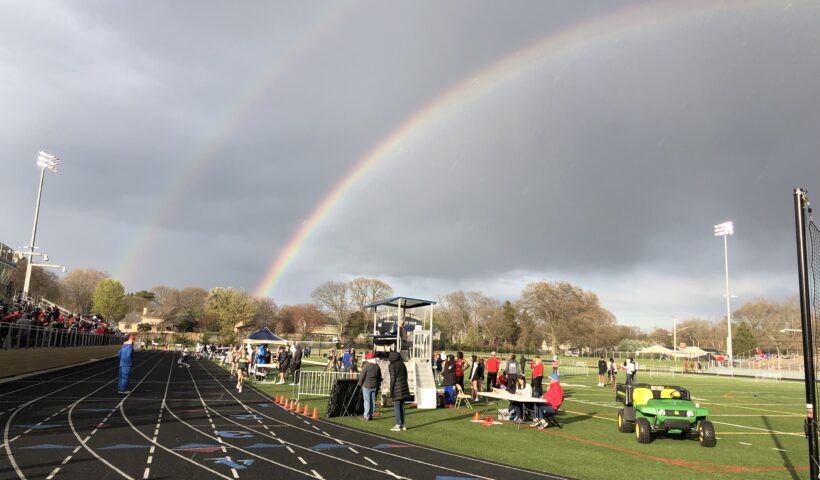A rainbow over the track at a sports field.