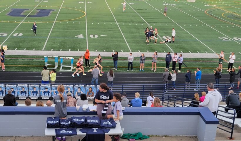 A crowd of people sitting at the bleachers.