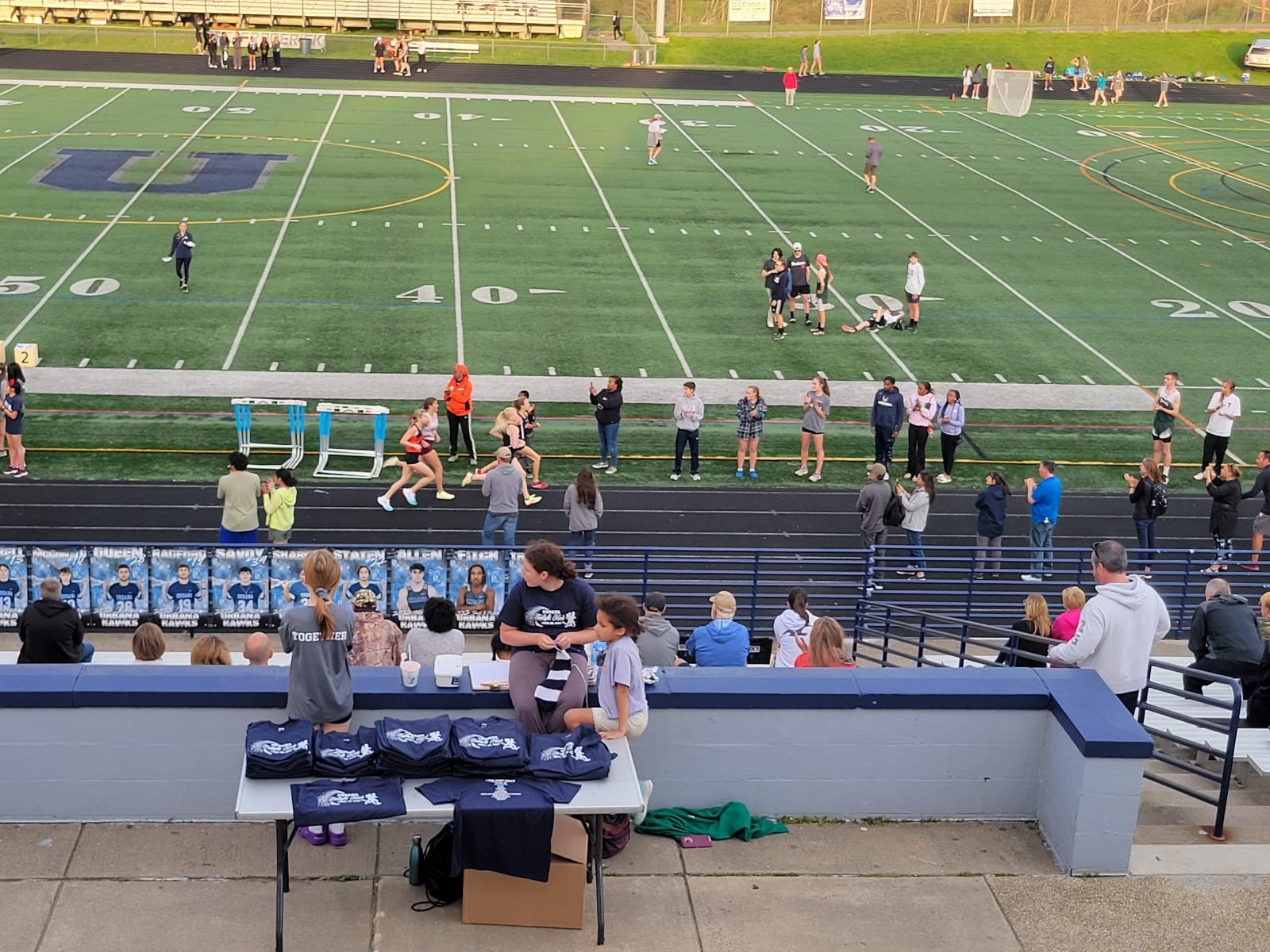 A crowd of people sitting at the bleachers.