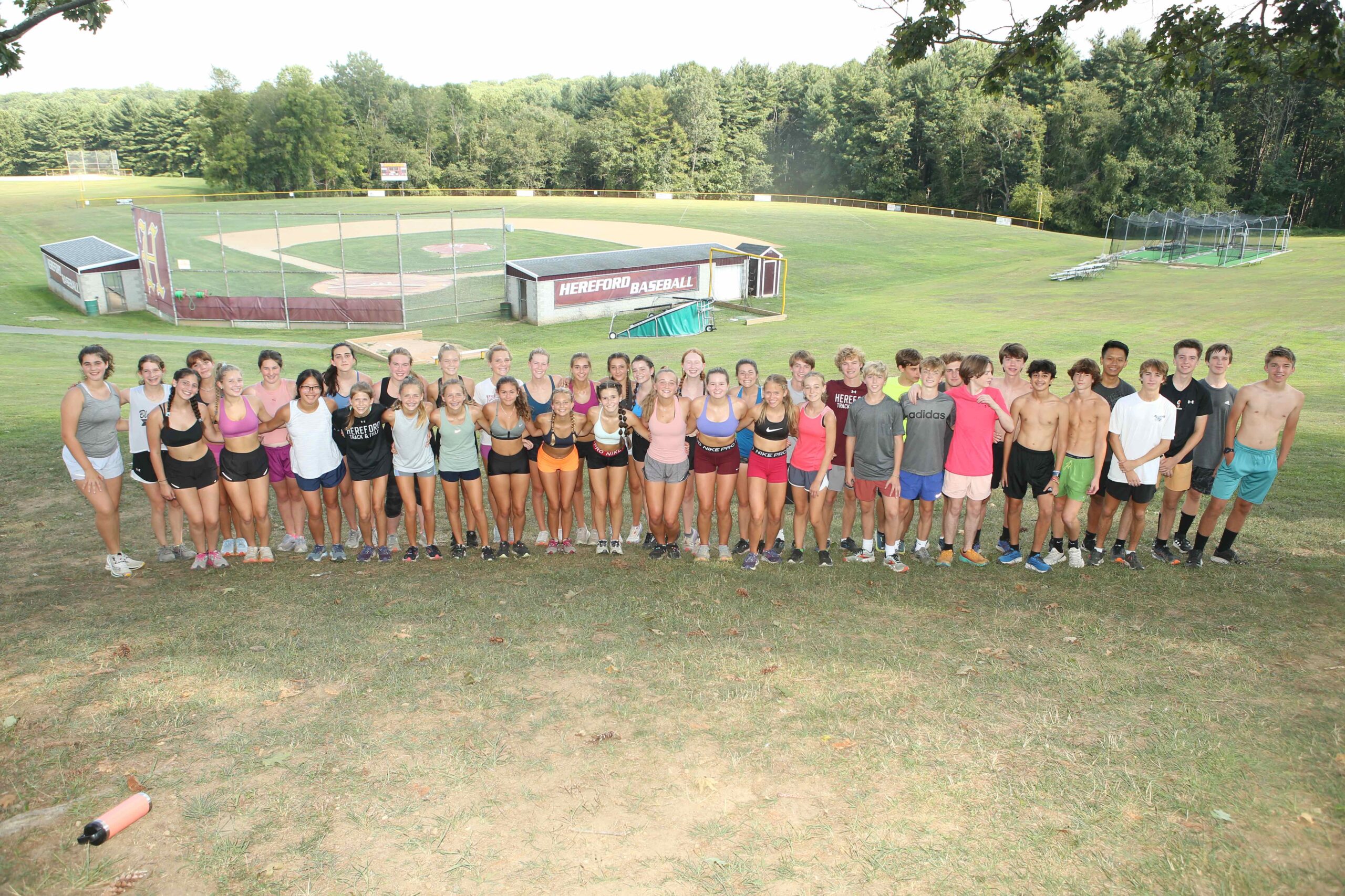 A group of people standing on top of a grass covered field.