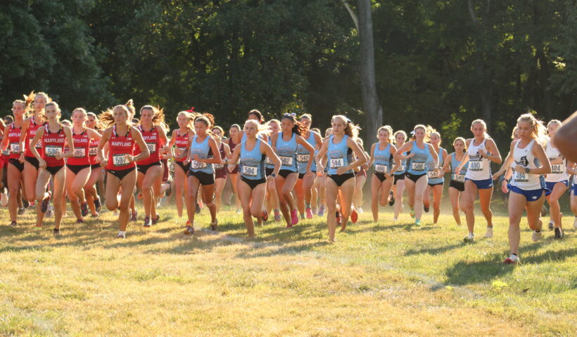 A group of women running in the grass.