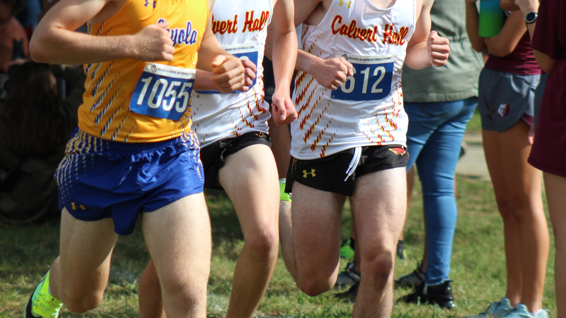 A group of young men running on the grass.