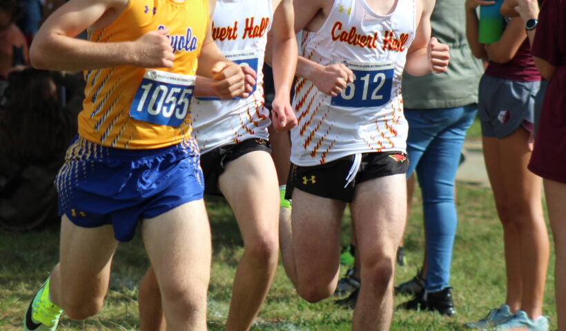 A group of young men running on the grass.