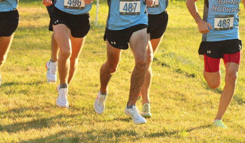 A group of young men running in the grass.