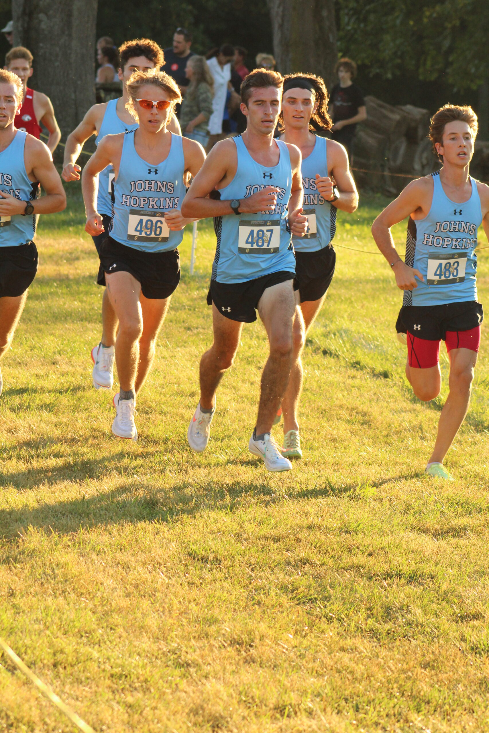 A group of young men running in the grass.