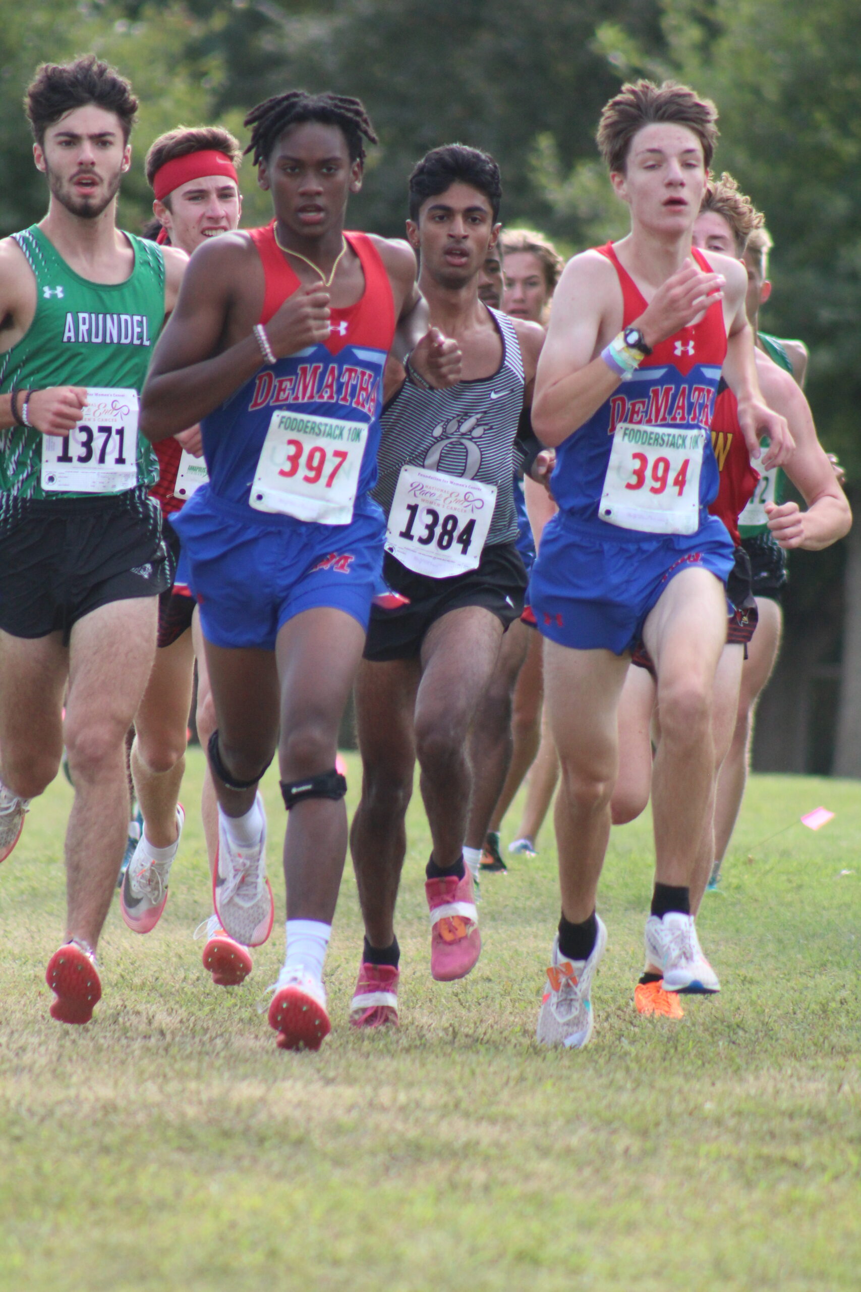 A group of men running in the grass.