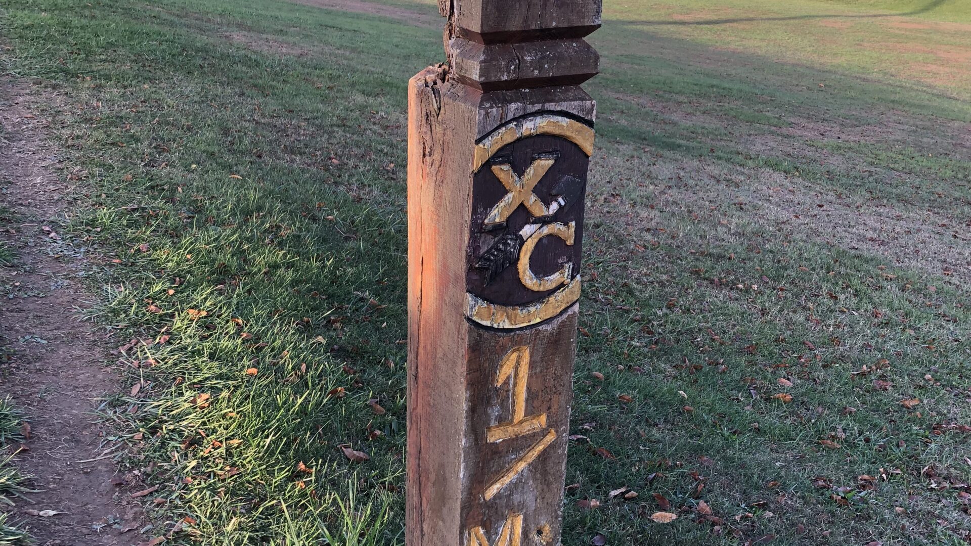 A wooden post with the initials xc and 1 m on it.