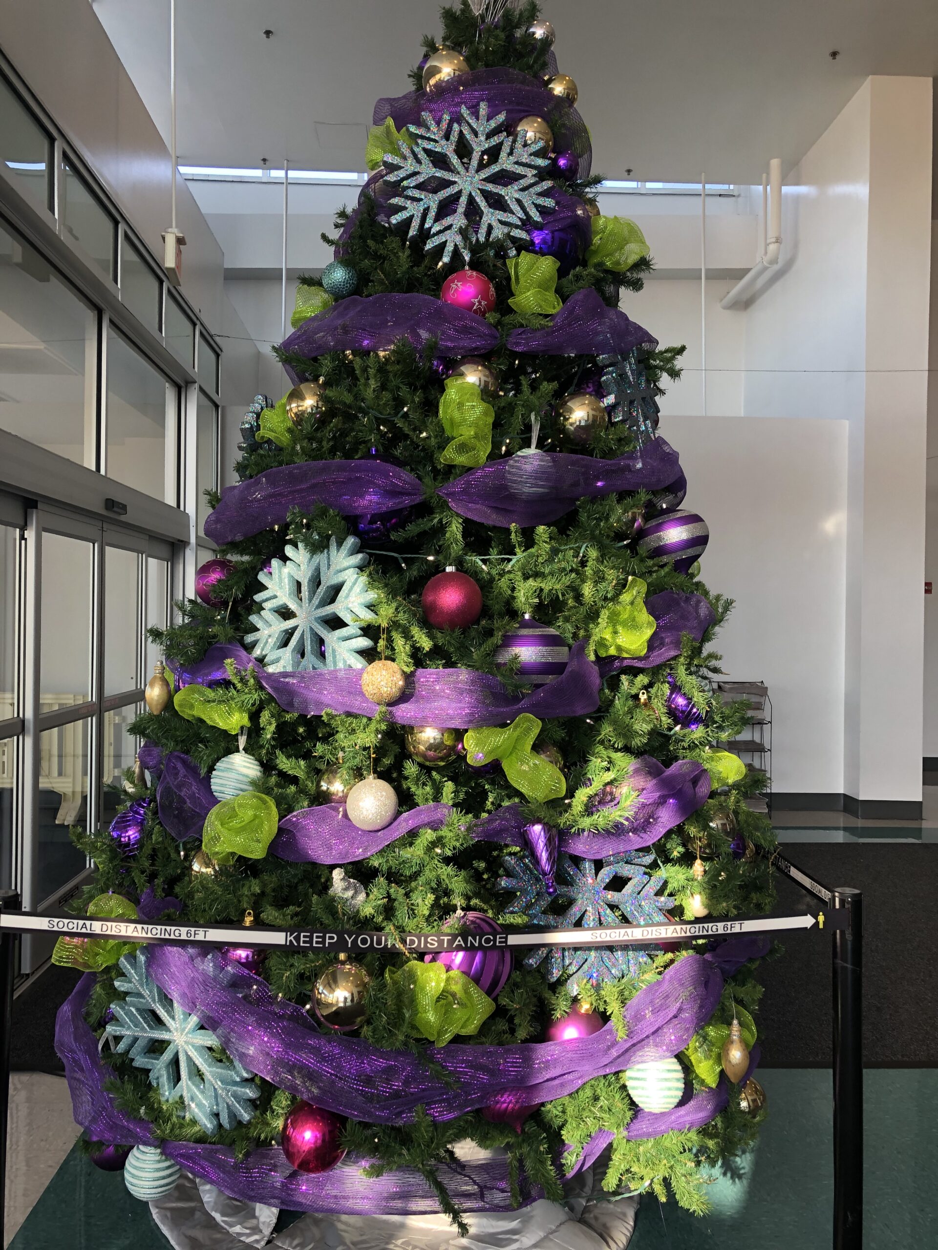 A christmas tree with purple decorations and green leaves.