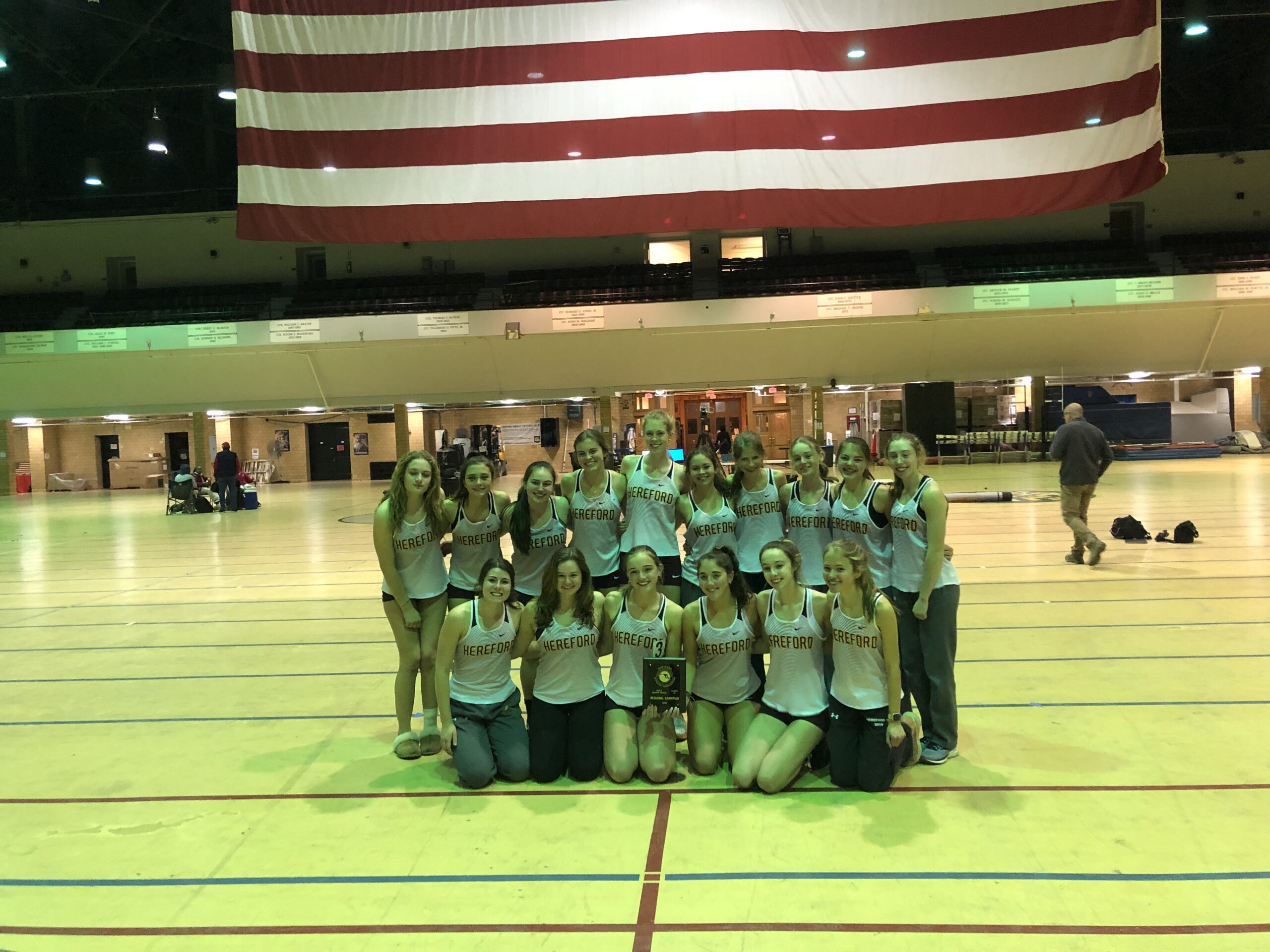 A group of people standing in front of an american flag.