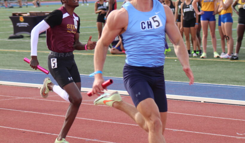 A man running on the track while holding a tennis racket.