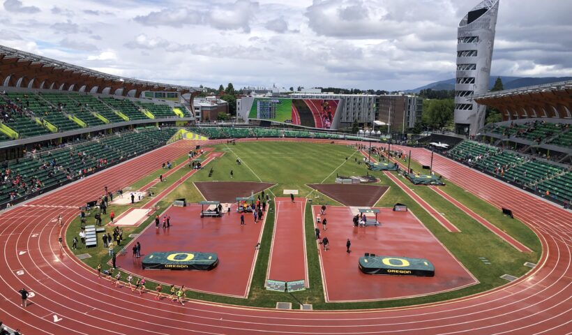 A view of an outdoor stadium with people on the track.