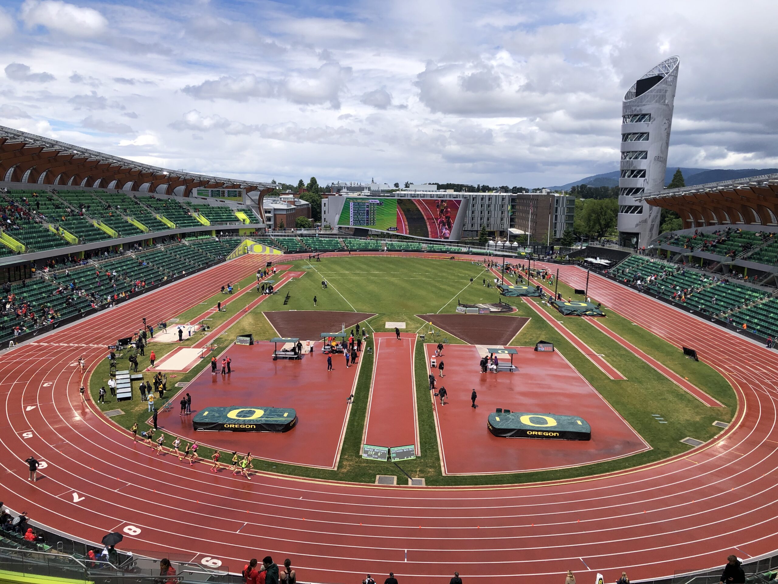 A view of an outdoor stadium with people on the track.