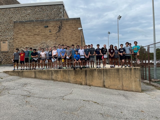 A group of people standing on top of a concrete wall.