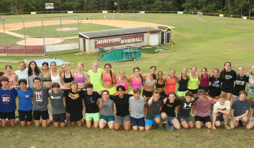 A group of people that are standing in the grass.