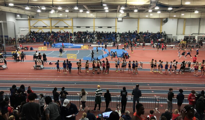 A crowd of people standing in an indoor arena.