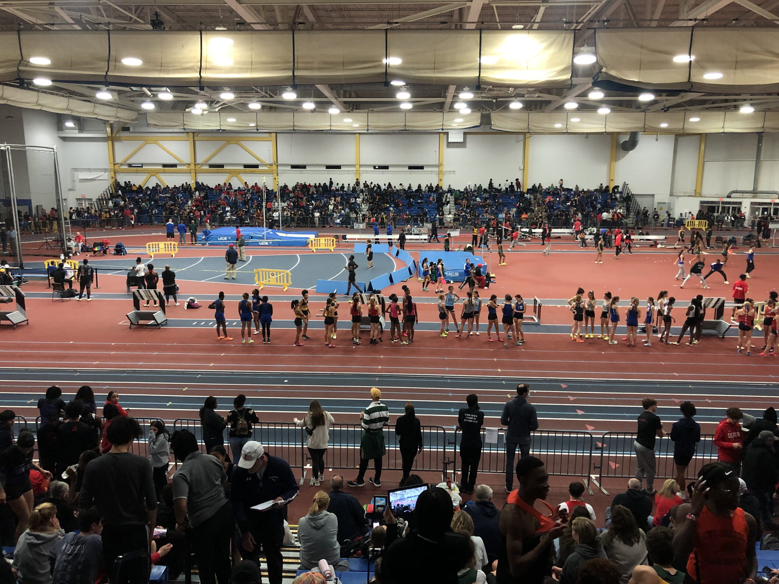 A crowd of people standing in an indoor arena.