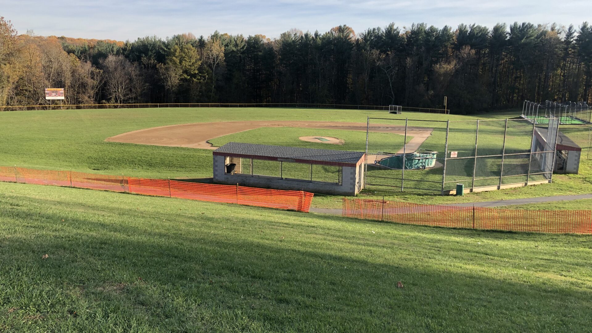 A baseball field with a bench and a fence.