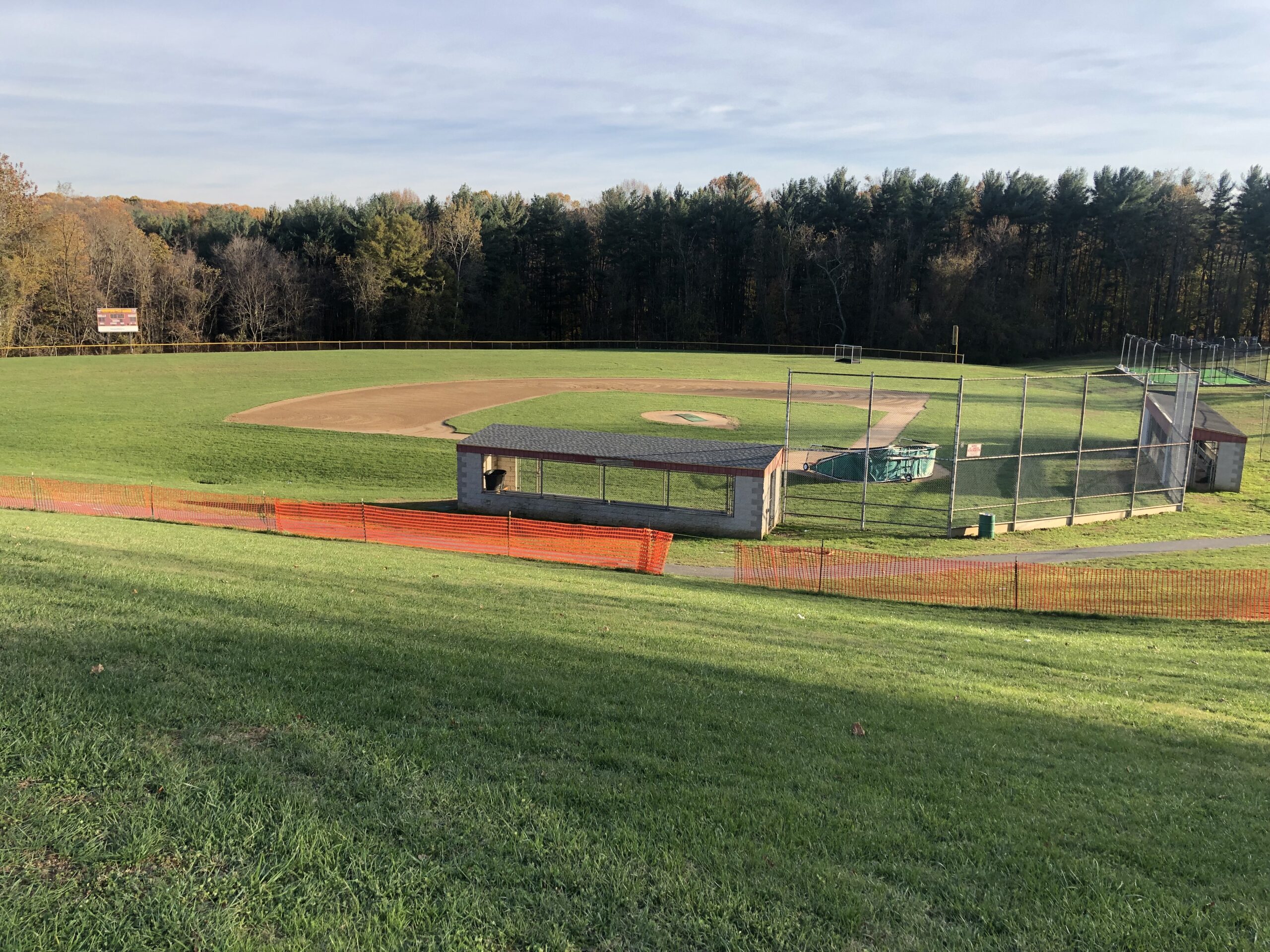 A baseball field with a bench and a fence.